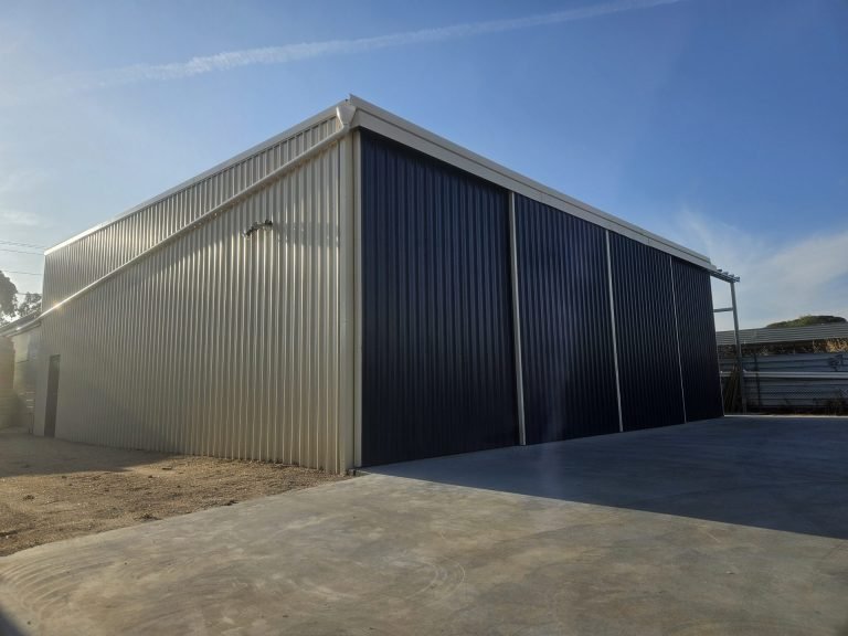 Large industrial steel shed with sliding doors and concrete apron in WA