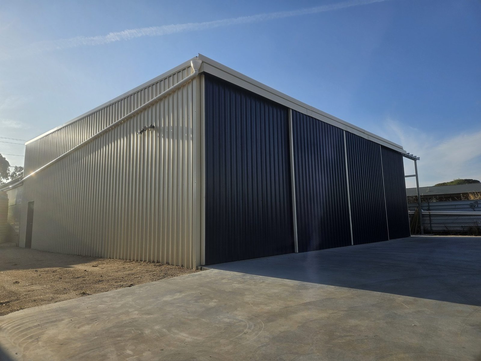 Large industrial steel shed with sliding doors and concrete apron in WA